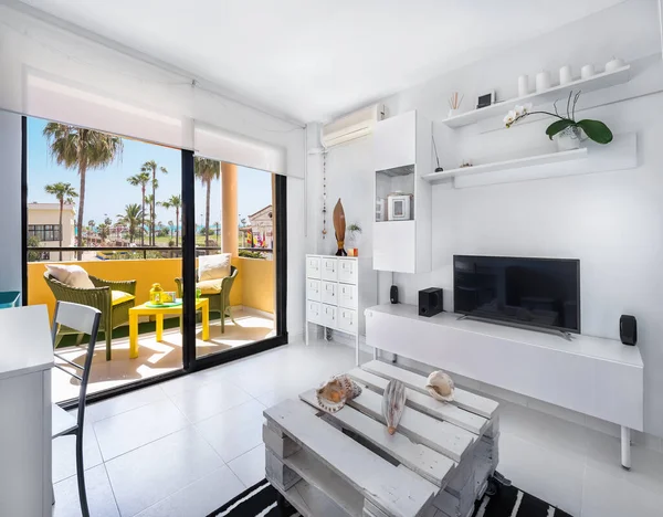 Bir tatil merkezinin oturma odasının modern iç dekorasyonu. Kanepe, televizyon ve deniz manzaralı bir daire.