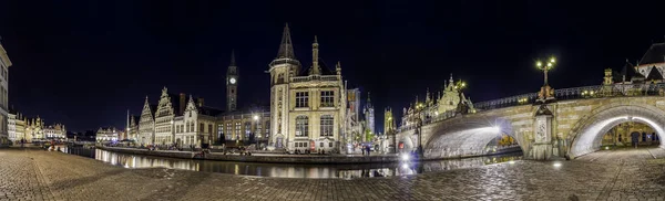 Graslei 'nin panoramik manzarası, Gent, Belçika' daki Lys Nehri 'nin yanındaki rıhtımda rıhtımda ve alacakaranlıkta St. Michael Köprüsü' nde. Gent eski kasabası geceleri aydınlık binalarıyla ünlüdür.. — Stok fotoğraf