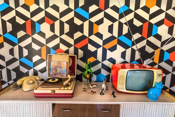 Vintage decoration with geometric wallpaper, retro tv, old portable record player, telephone and ceramic. — Stock Photo, Image