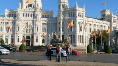 Madrid, İspanya. Aralık 2018. Arka planda Cibeles çeşmesi ve Madrid Belediye Binası ile fotoğraf çeken turistler, eski Haberleşme Sarayı