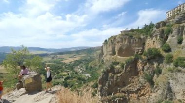 Ronda, İspanya. Şubat 2019 civarı. İspanya 'nın antik Ronda kentindeki Puente Nuevo köprüsüne ve uçurumun kenarına inşa edilen evlere resim çeken bir turist..