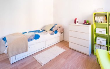 Yatak, yorgan, yan masalar, lambalar ve bitkilerle dolu renkli, parlak bir yatak odası. Minimalist beyaz stil iç mekan