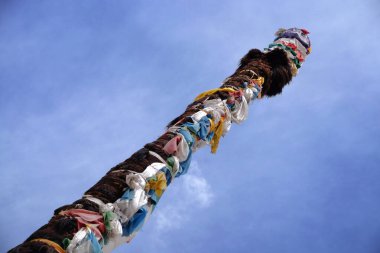 Tibet, Lhasa 'daki Sera Manastırı' nın ön avlusunda öküz derisi ve dua eden bayraklarla kaplı din sütunları..