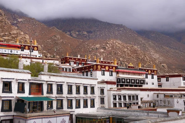 Vista de las montañas de color marrón que rodean las paredes blancas del Monasterio Drepung en Lhasa, Tibet . — Foto de Stock