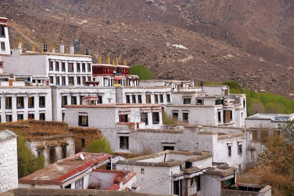 Vista de las montañas de color marrón que rodean las paredes blancas del Monasterio Drepung en Lhasa, Tibet . — Foto de Stock