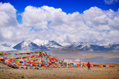 Tibet bayrakları Himalaya Dağları 'na karşı karla kaplı, açık mavi gökyüzüne karşı..