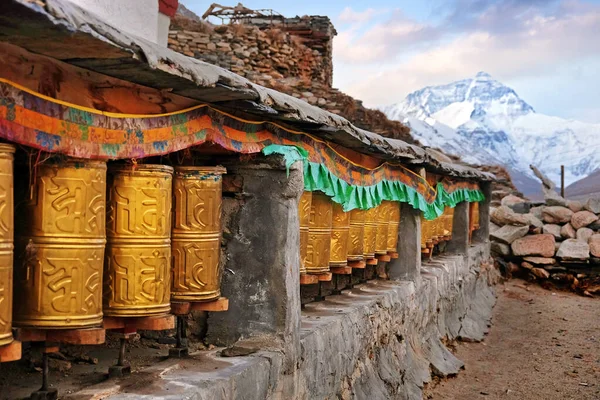 View of golden praying wheels and Mount Everest in the background from the RongPu Monastery in Tibet, against a cold morning sky. — Stockfoto