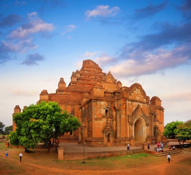 Eski Bagan, Myanmar 'da yeşil bitki örtüsüyle çevrili eski bir tapınağın üstündeki renkli gökyüzü..