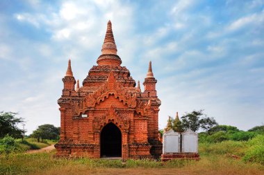 Eski Bagan, Myanmar 'daki yeşil bitki örtüsüyle çevrili tapınakların üstündeki mavi gökyüzü.