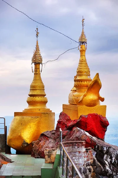 Golden towers on the walls of Buddhist temple of Mount Popa, in Myanmar, against a blue sky. — 图库照片