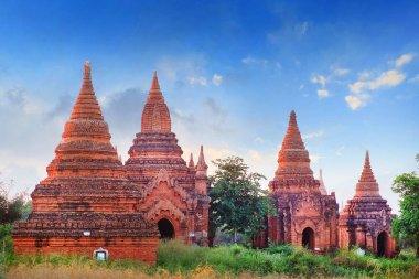 Eski Bagan, Myanmar 'daki yeşil bitki örtüsüyle çevrili tapınakların üstündeki mavi gökyüzü.