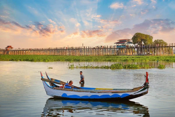 Красочная традиционная лодка на озере Taung Tha Man, рядом с мостом U Bein, рядом с Мандалаем, против красивого красочного неба заката . — стоковое фото