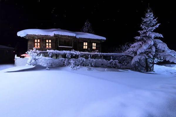 Brushlian village, Bulgaristan, 31 Aralık 2016. Eski ahşap evi penceresinde bir ışıkla. Kışın gece manzarası — Stok fotoğraf