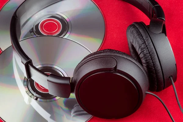 CD y auriculares sobre fondo rojo — Foto de Stock