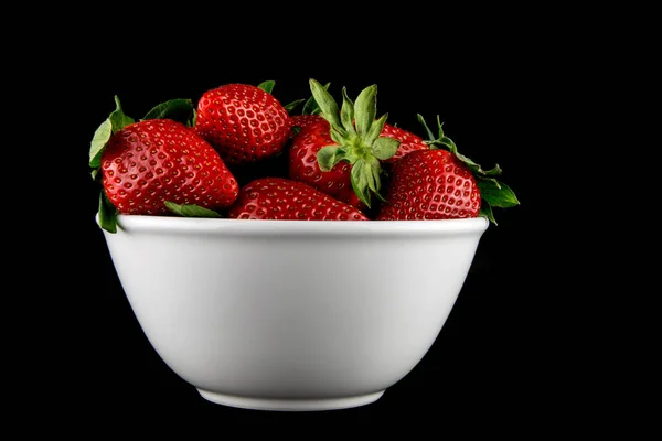 Tazón de cerámica de fresas sobre un fondo negro — Foto de Stock