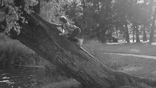 A menina está brincando em um belo parque de verão, iluminado pelo sol . — Vídeo de Stock