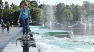 Güzel kız çeşme büyük bir şehir sokakta oynuyor. 