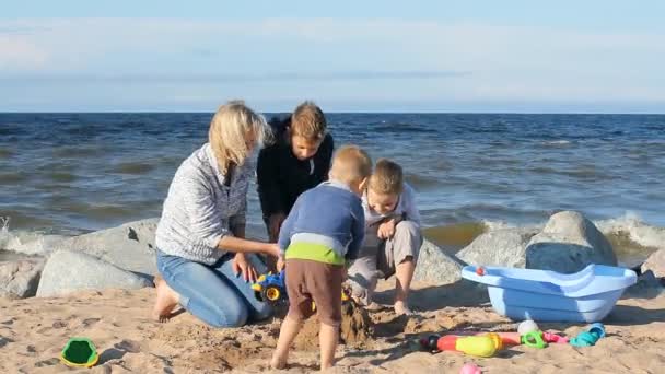 はしゃいで 遊んで 走り回っている子供を持つ若い女性の家族の休暇 歳の男の子がビーチで遊ぶ — ストック動画