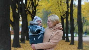 Genç kadın kucağında bir bebekle. Anne ve oğlu güzel bir sonbahar Park'ta dinlenme.