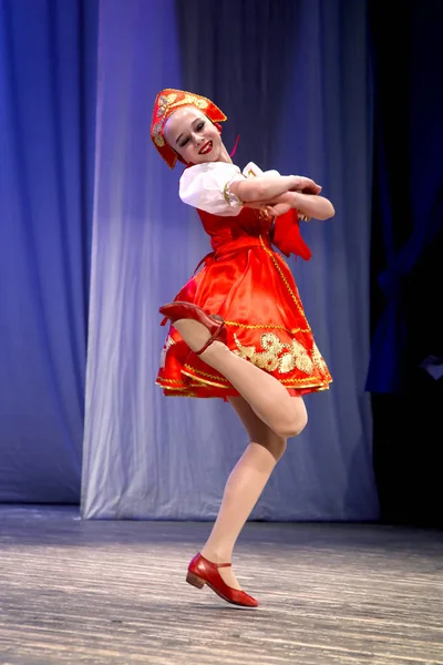 Ρωσικό λαϊκό χορό - κορίτσι με τα εθνικά φορέματα της σεζόν άλμα στη σκηνή — Φωτογραφία Αρχείου