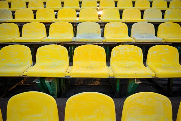 Старое жёлтое сиденье на стадионе — стоковое фото