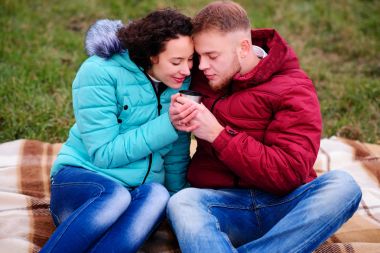 bir termo ekose ve içecek kahve oturan genç Çift