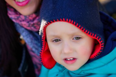 Şirin meraklı küçük çocuk bir kap içinde sarı yaprak ile kapatın. Sonbahar
