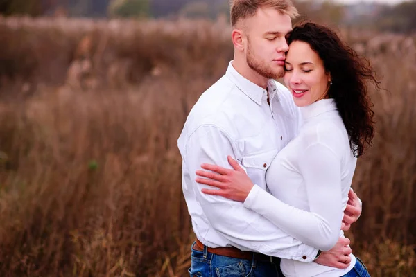 Jovem casal abraçar em paisagens outonais com olhos fechados, wh — Fotografia de Stock