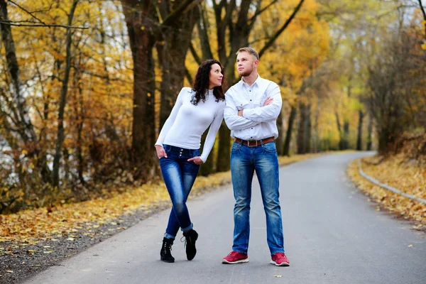 Joven pareja enamorada de pie en la carretera junto a un hermoso día de otoño —  Fotos de Stock