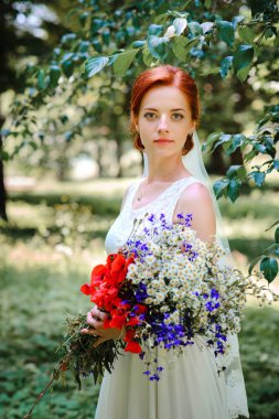 Uzun saç ve ayçiçeği alanında bir buket ile zarif sarı gelin