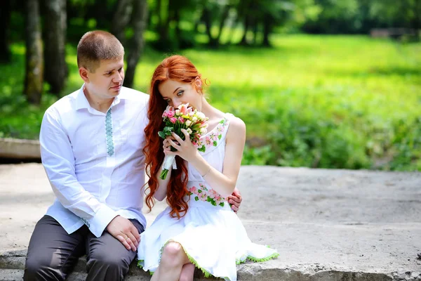 Groom fixe son noeud papillon bleu debout devant la mariée sur un vieux pont de pierre — Photo