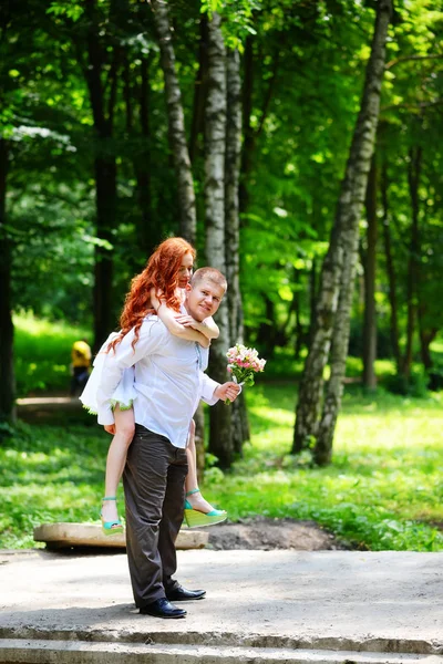 De bruid en bruidegom in het Park.A paar jonggehuwden, de bruid en bruidegom op de bruiloft in de natuur van het groene bos kussen foto. Bruiloft Couple.Wedding lopen — Stockfoto