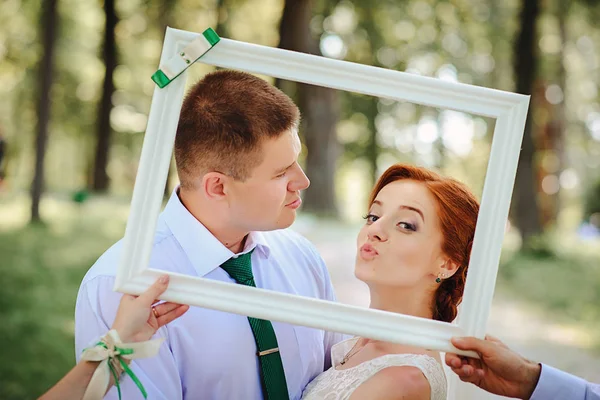 Vőlegény és menyasszony pózol egy fehér keret — Stock Fotó