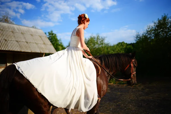 Retrato de uma noiva a cavalo no fundo de um pôr-do-sol de verão — Fotografia de Stock