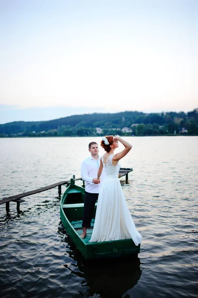 Jovem casal apaixonado sentado em um pequeno barco e se divertindo — Fotografia de Stock