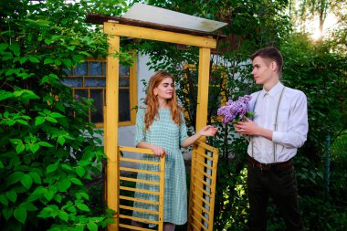 adam kız arkadaşı leylak bir buket verir, o kapıdan geldi