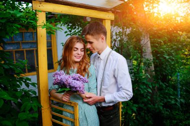 adam kız arkadaşı leylak bir buket verir.