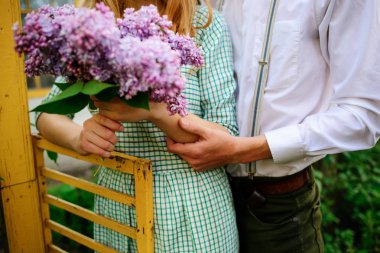 adam bir buket leylak tutan kız arkadaşı sarılma