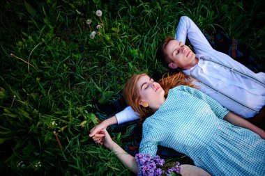 Genç çift çim üzerinde yalan ve sakin ol, yukarıdan görüntülemek