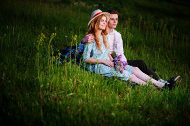 Genç çift ekose parkta oturan ve gün batımında bak