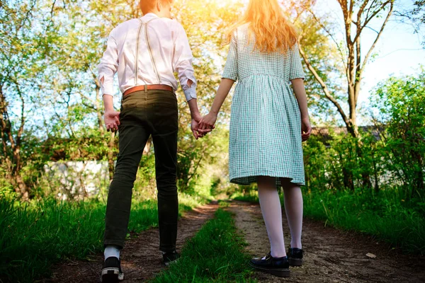 Man goes with his girlfriend on the road, low angle, Back view — Stock Photo, Image