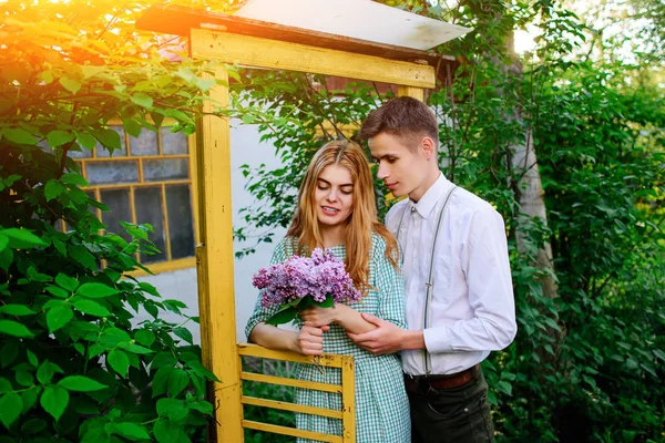 Cara dá a sua namorada um buquê de lilases — Fotografia de Stock