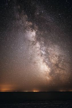 Samanyolu onu ve su üzerinde ışık ile parlak ve gece yıldızlı gökyüzü arka plan