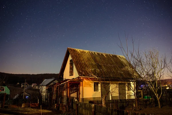Trähus på en bakgrund av natthimlen — Stockfoto