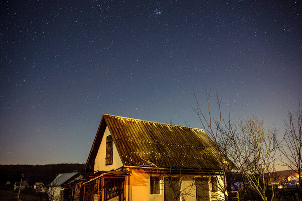 wooden house on a background of the night sky