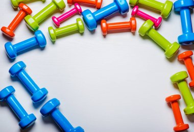 birçok mavi yeşil ve beyaz bir arka plan üzerinde orta dumbbells bir turuncu, kavram, fitness hazırlama ekipmanları üstten görünüm sahte kadar spor