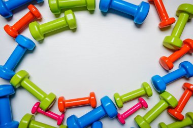birçok mavi yeşil ve beyaz bir arka plan üzerinde orta dumbbells bir turuncu, kavram, fitness hazırlama ekipmanları üstten görünüm sahte kadar spor