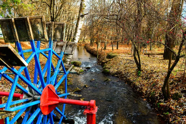 Moinho de água de roda metálica em um parque — Fotografia de Stock