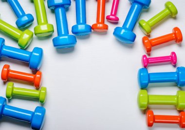 birçok mavi yeşil ve beyaz bir arka plan üzerinde orta dumbbells bir turuncu, kavram, fitness hazırlama ekipmanları üstten görünüm sahte kadar spor