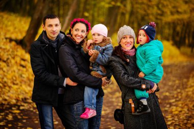 İki çocuklu aile sonbahar Park'ta yürüyordunuz